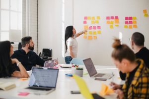 Colleagues planning a project with sticky notes on a glass wall
