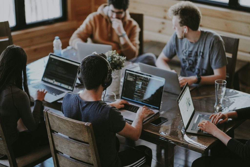 A team working together on laptops around a shared table